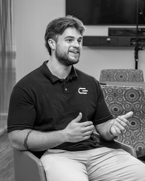 Gabe Allen, seated and mid-conversation, in a polo with the Given mark
